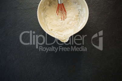 Overhead view of batter with wire whisk in bowl