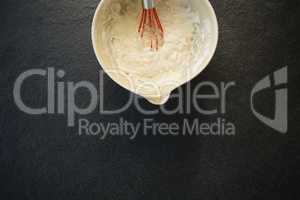 Overhead view of batter with wire whisk in bowl