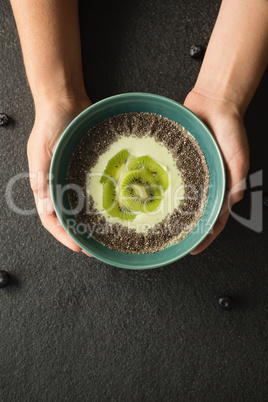 Hands holding a bowl of fruit cereal