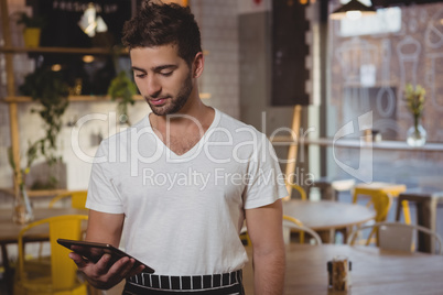 Waiter holding digital tablet in cafe