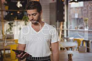 Waiter holding digital tablet in cafe