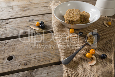 Granola bar and berry fruit on wooden table