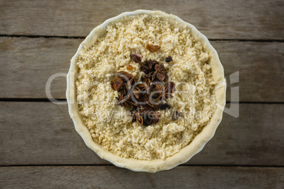 Overhead view of star anise and raisins on food in tart