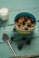 Bowl of cereals and blueberries with glass of milk for breakfast