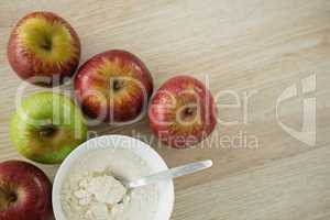 Overhead view of flour in bowl by apples