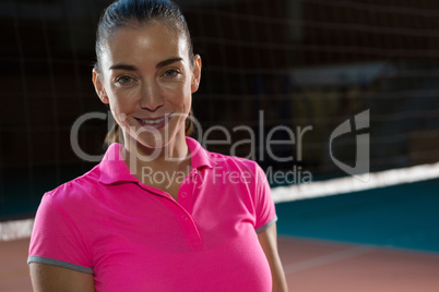 Portrait of confident volleyball player by net