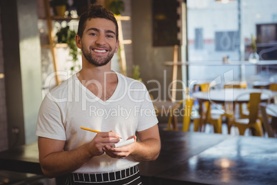 Portrait of smiling waiter taking order