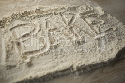 High angle view of bake text on flour