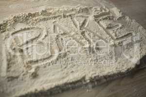 High angle view of bake text on flour