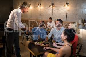 Friends shaking hands while having meal