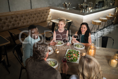 Group of friends interacting with each other while dining