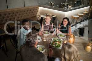 Group of friends interacting with each other while dining