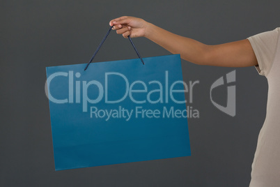 Cropped image of woman holding blue shopping bag