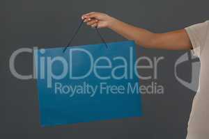 Cropped image of woman holding blue shopping bag