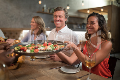 Friends passing food to each other while dining