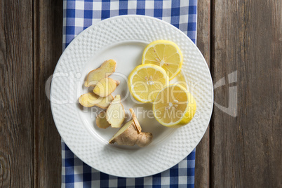 Lemon and ginger slices in plate on table