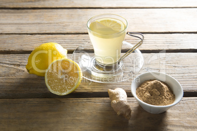 Tea cup with lemon and ginger on wooden table