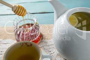Close-up of honey with ginger tea kettle