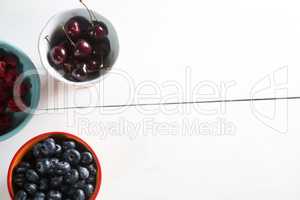 Overhead view of cherries and berries in bowls