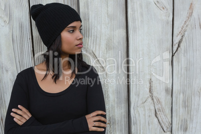 Thoughtful young woman standing with arms crossed