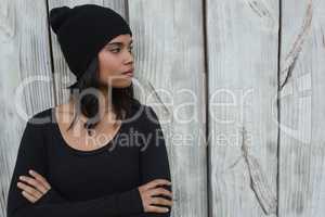 Thoughtful young woman standing with arms crossed