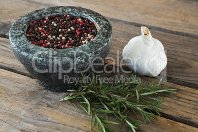 Garlics, rosemary and mix peppercorns on chopping board