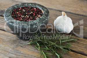 Garlics, rosemary and mix peppercorns on chopping board