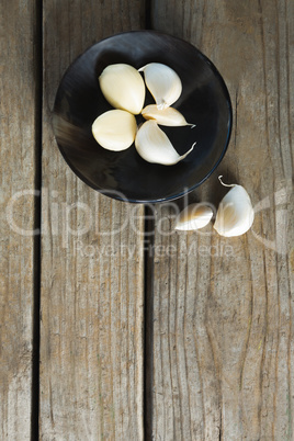 Garlics in plate on wooden table