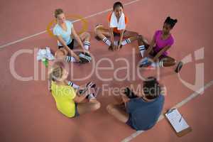Coach and female player doing stretching exercise