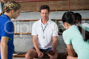 Volleyball coach talking to female players