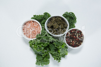 Overhead view of salt and peppercorn with kale