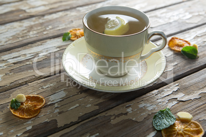 High angle view of lemon and mint leaves in ginger tea on weathered table