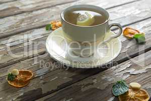 High angle view of lemon and mint leaves in ginger tea on weathered table