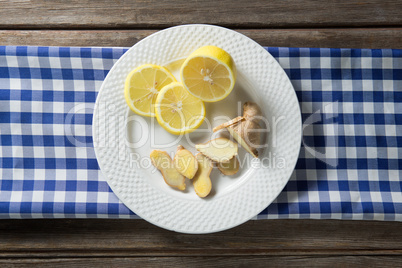 Lemon and ginger in plate with napkin on table