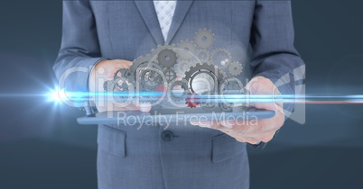 business man holding tablet with 3 d cogs on it