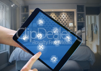 Hand holding tablet with smart home interface at home