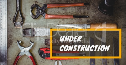 Under construction message on images of tools laid on table