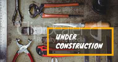 Under construction message on images of tools laid on table