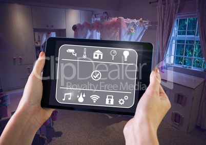 Hand holding tablet with smart home interface at home