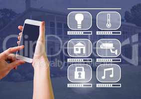 Hand holding phone with smart home interface at home