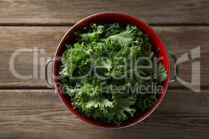 Overhead view of kale in colander on table