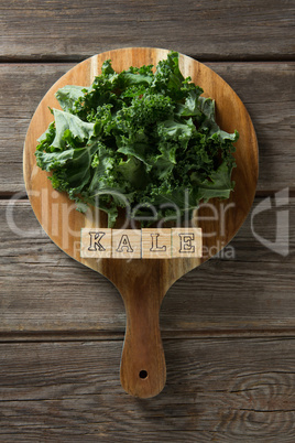 Kale leaves with text on cutting board at table