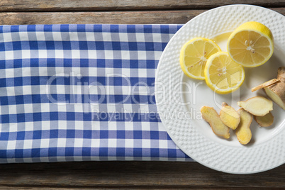 Lemon and ginger in plate on table