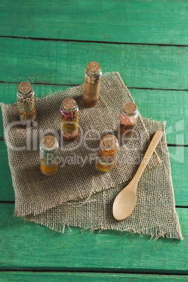 Various spices in bottles on wooden table