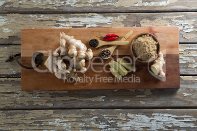 Directly above view of various spices on serving board over weathered table