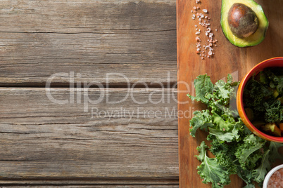 Kale with avocado and rock salt on cutting board