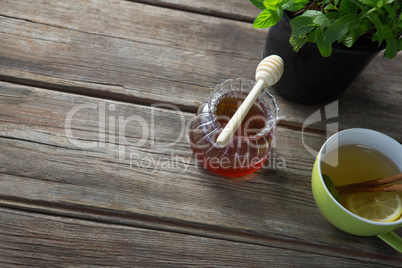 High angle view of honey with ginger tea on table