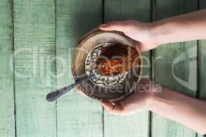 Hand holding chili powder and crushed red pepper in bowl