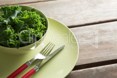 Close-up of kale in bowl on plate over table