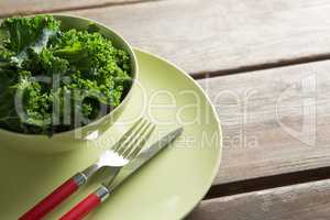 Close-up of kale in bowl on plate over table